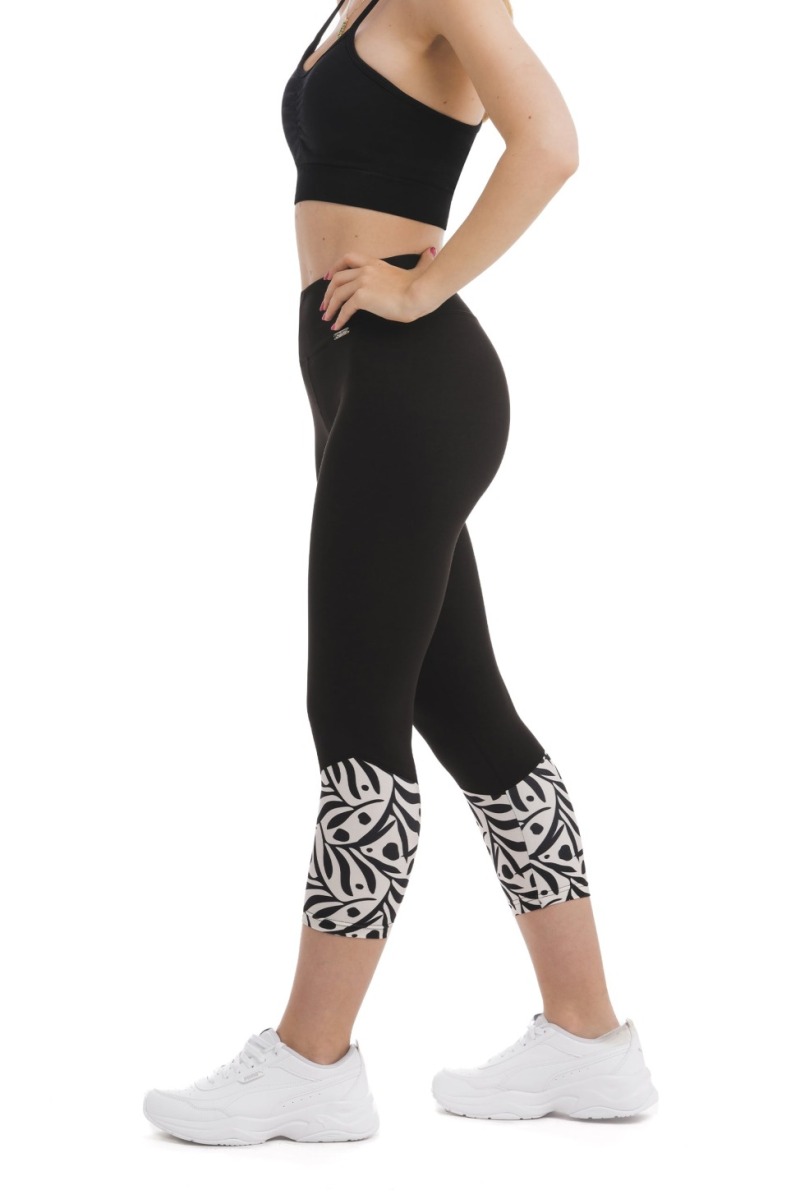 Črne capri pajkice Zampilo s črnim abstraktnim vzorcem listov in pik na belem ozadju na dnu hlačnic