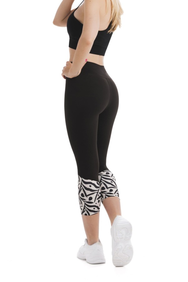 Črne capri pajkice Zampilo s črnim abstraktnim vzorcem listov in pik na belem ozadju na dnu hlačnic