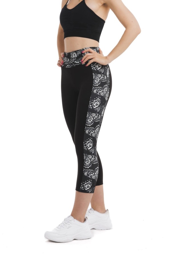 Črne capri pajkice z abstraktnim vzorcem metuljem v beli barvi ob straneh hlačnic in na pasu