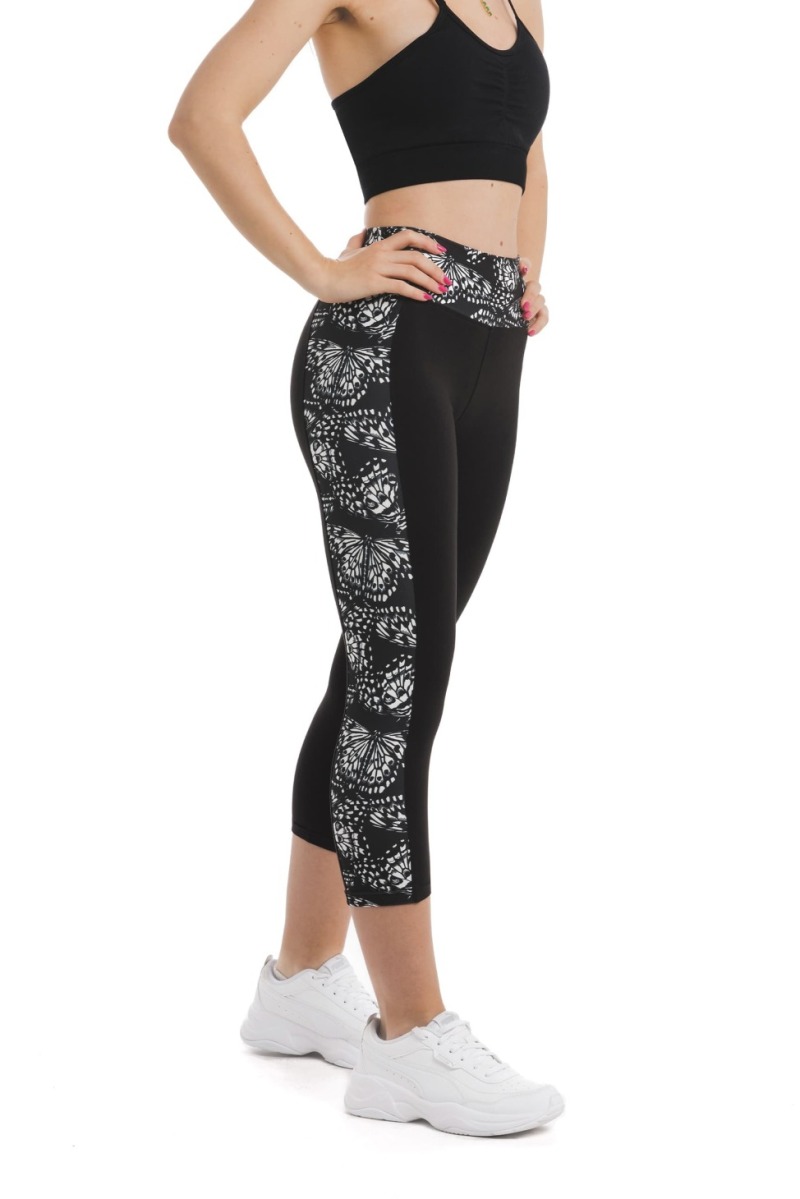 Črne capri pajkice z abstraktnim vzorcem metuljem v beli barvi ob straneh hlačnic in na pasu